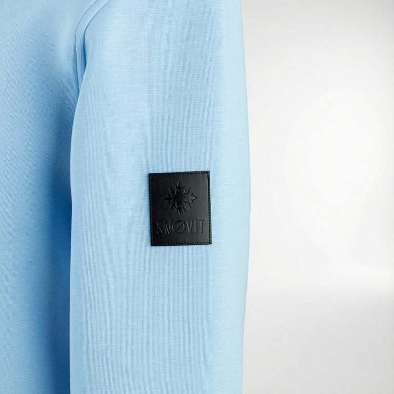 Nahaufnahme des blauen SNØVIT Deep Horizon Sweatshirts mit einzigartigem Lederpatch.