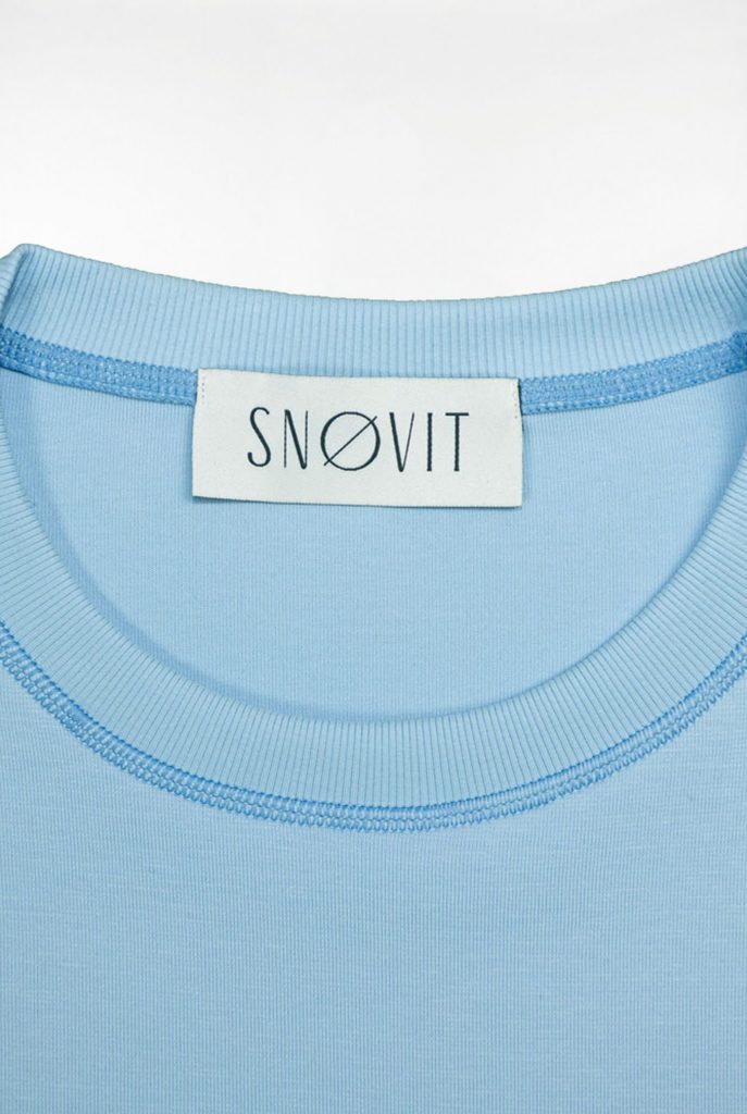 Nahaufnahme des blauen SNØVIT Brand-Tags im Deep Horizon Sweatshirt, Details des Stoffes sichtbar.