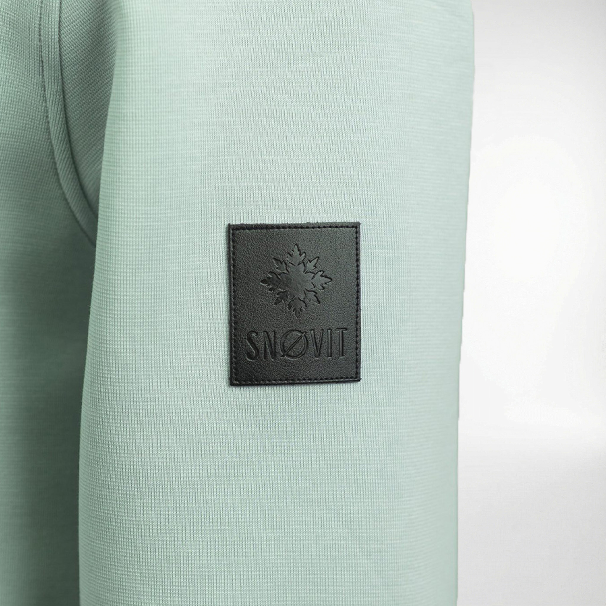 Nahaufnahme des einzigartigen Lederpatches am hellgrauen Arctic La Goone Sweatshirt von SNØVIT.