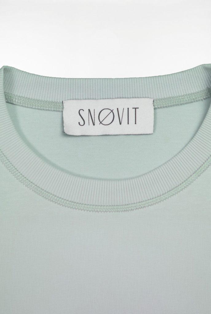 Nahaufnahme des SNØVIT Brand Tags im hellgrauen Arctic La Goone Sweatshirt.