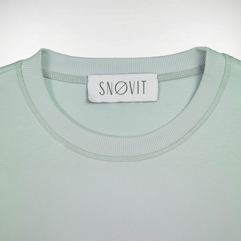 Nahaufnahme des SNØVIT Brand Tags im hellgrauen Arctic La Goone Sweatshirt.