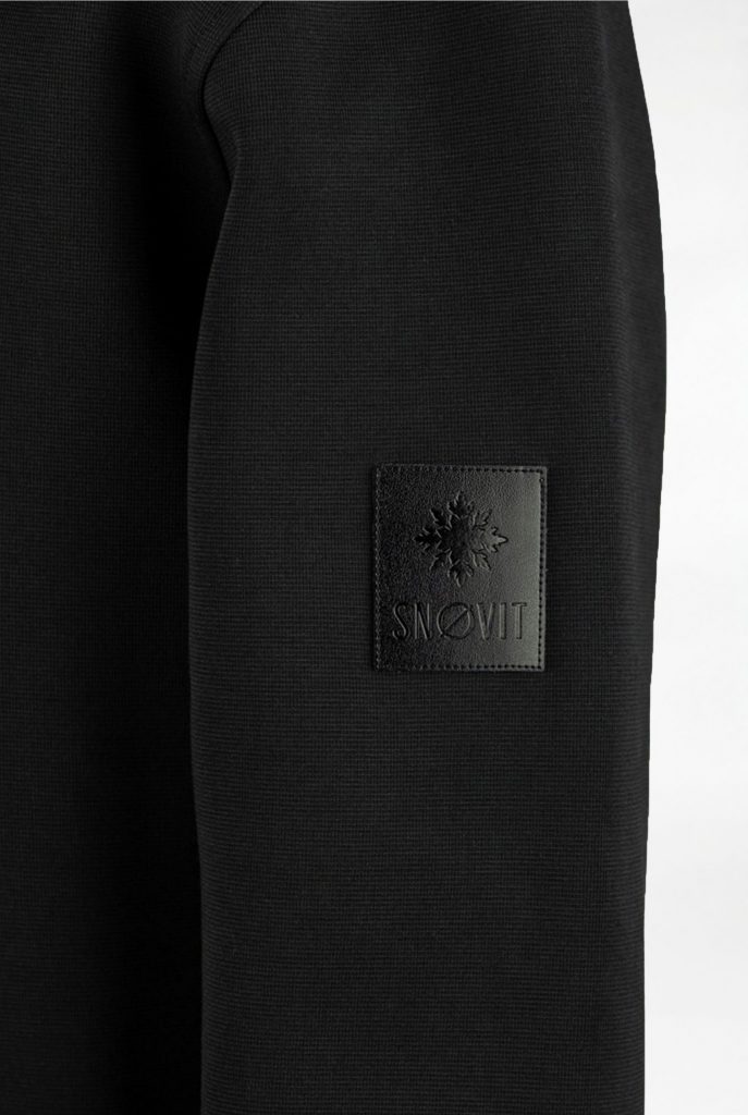 Nahaufnahme des schwarzen SNØVIT Midnight Cøre Sweatshirts mit einzigartigem Lederpatch.