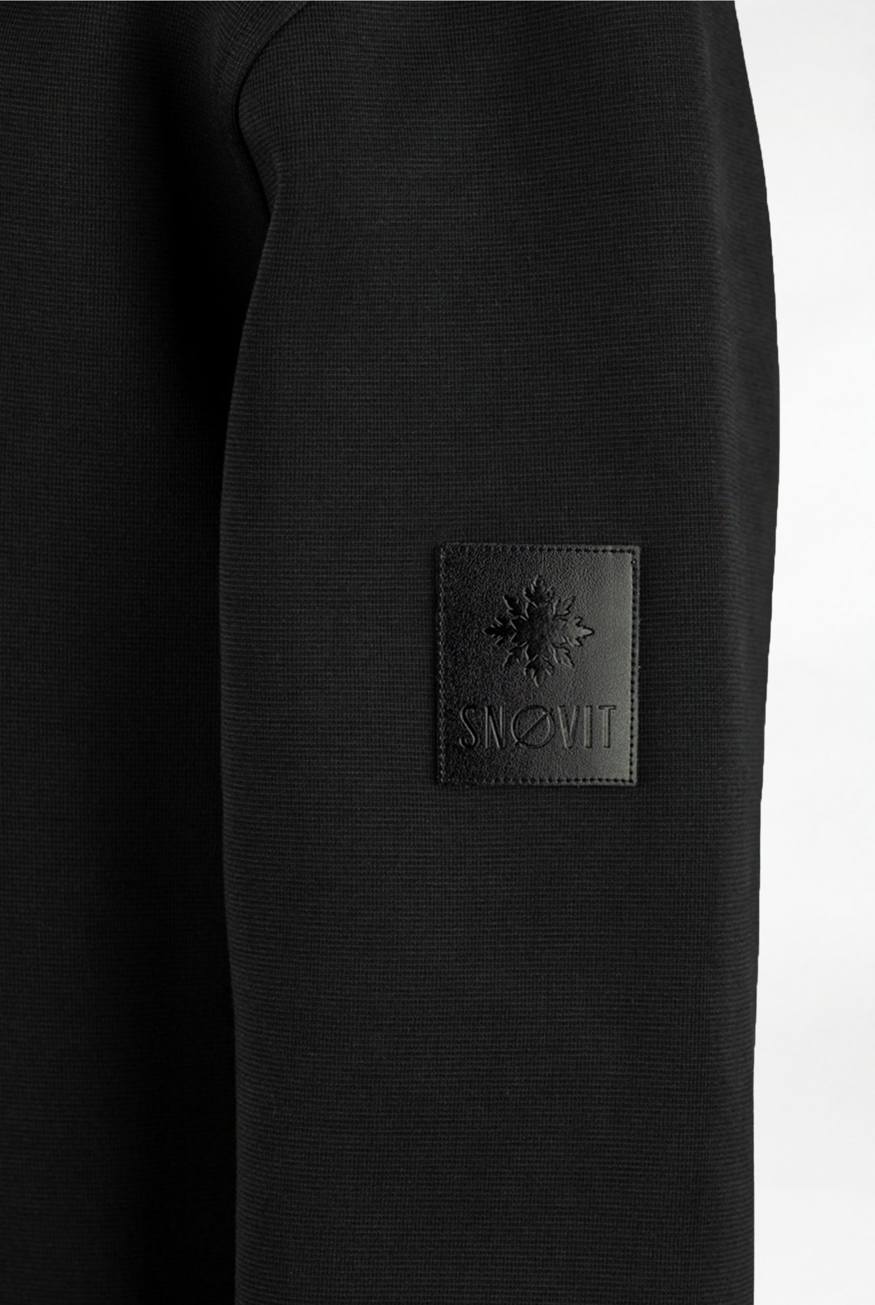 Nahaufnahme des schwarzen SNØVIT Midnight Cøre Sweatshirts mit einzigartigem Lederpatch.