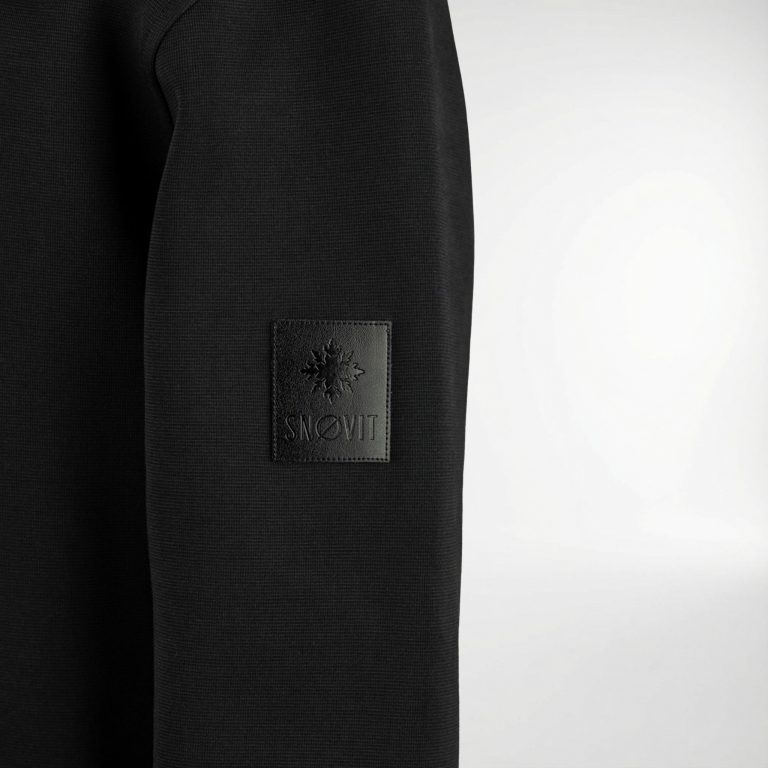 Nahaufnahme des schwarzen SNØVIT Midnight Cøre Sweatshirts mit einzigartigem Lederpatch.