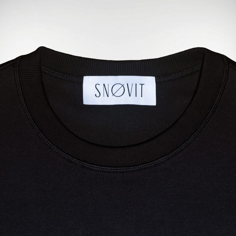 Nahaufnahme des schwarzen SNØVIT Brand-Tags im Midnight Cøre Sweatshirt, Details des Stoffes sichtbar.