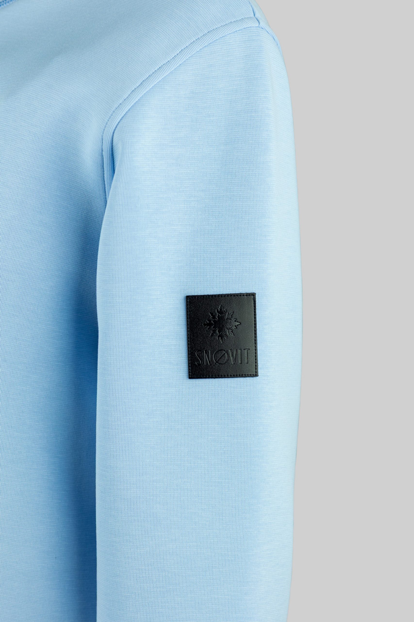 Nahaufnahme des blauen SNØVIT Deep Horizon Sweatshirts mit einzigartigem Lederpatch.