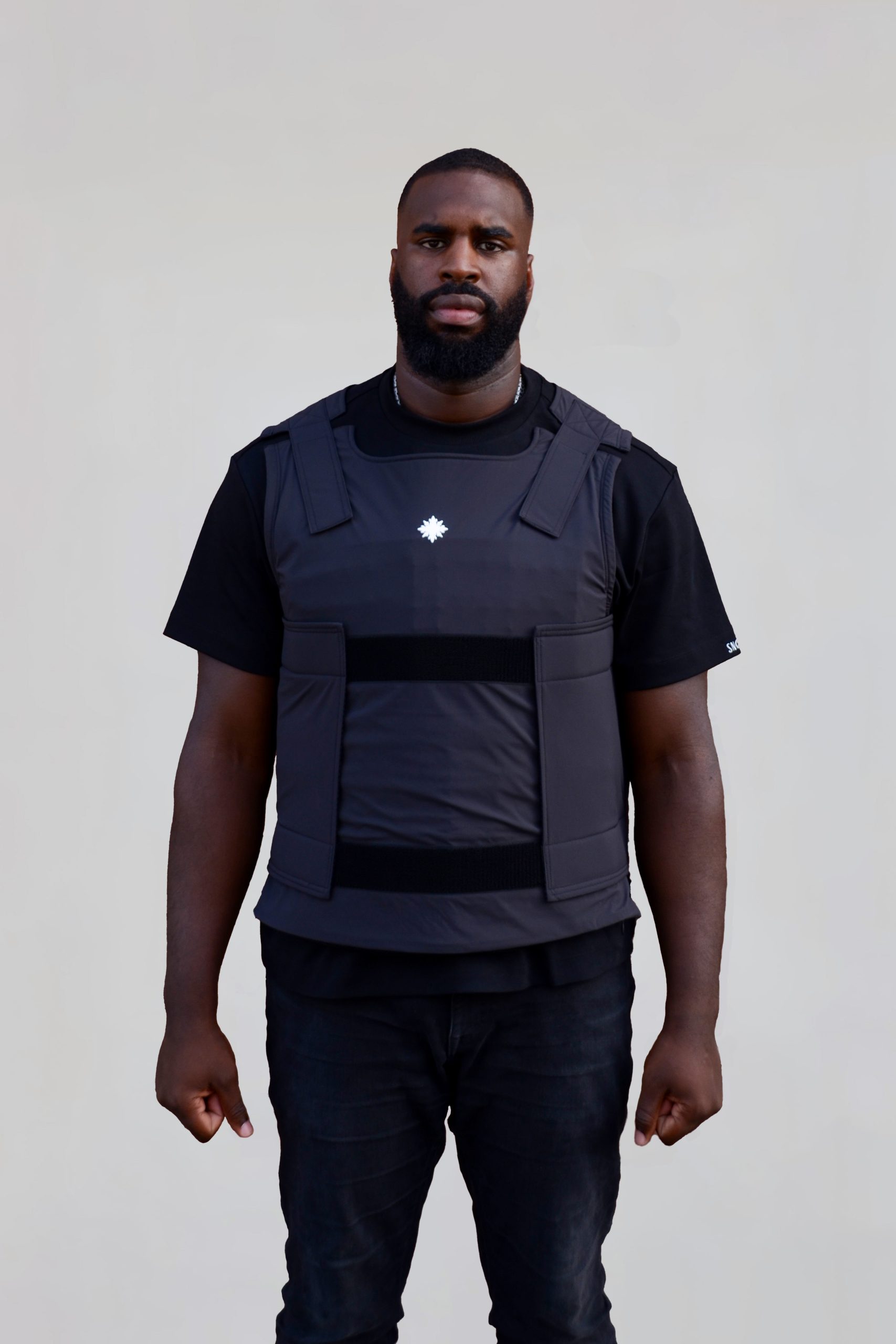 Model trägt schwarze Mayday X Weste mit VPAM zertifizierten Panelen innen und schaut geradeaus.