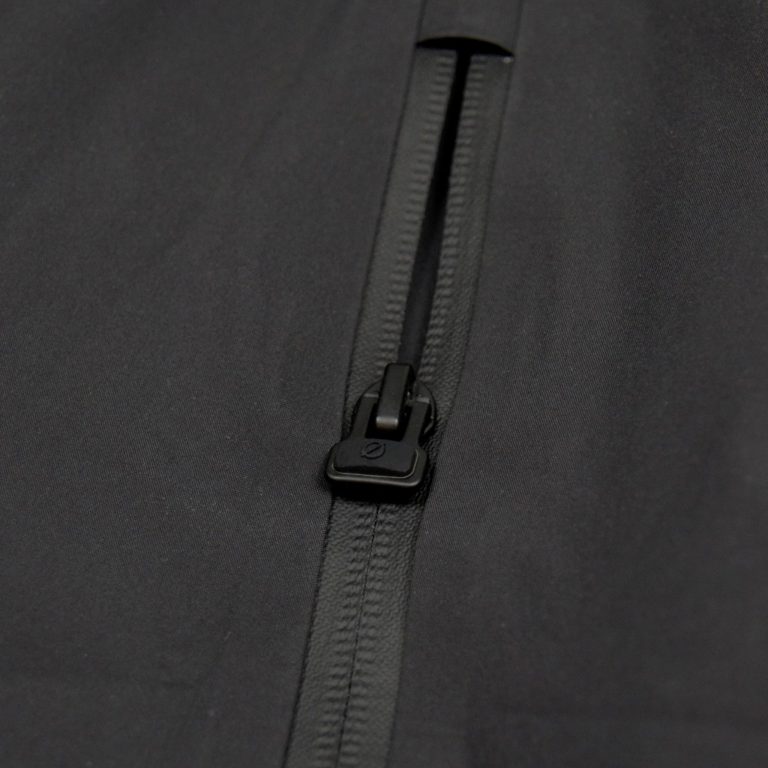 Detailaufnahme des hochwertigen Zipper-Accessoires mit ergonomischem Ø-Öffner an der schwarzen SNØVIT Nithya Nøva X Outdoor-Jacke.