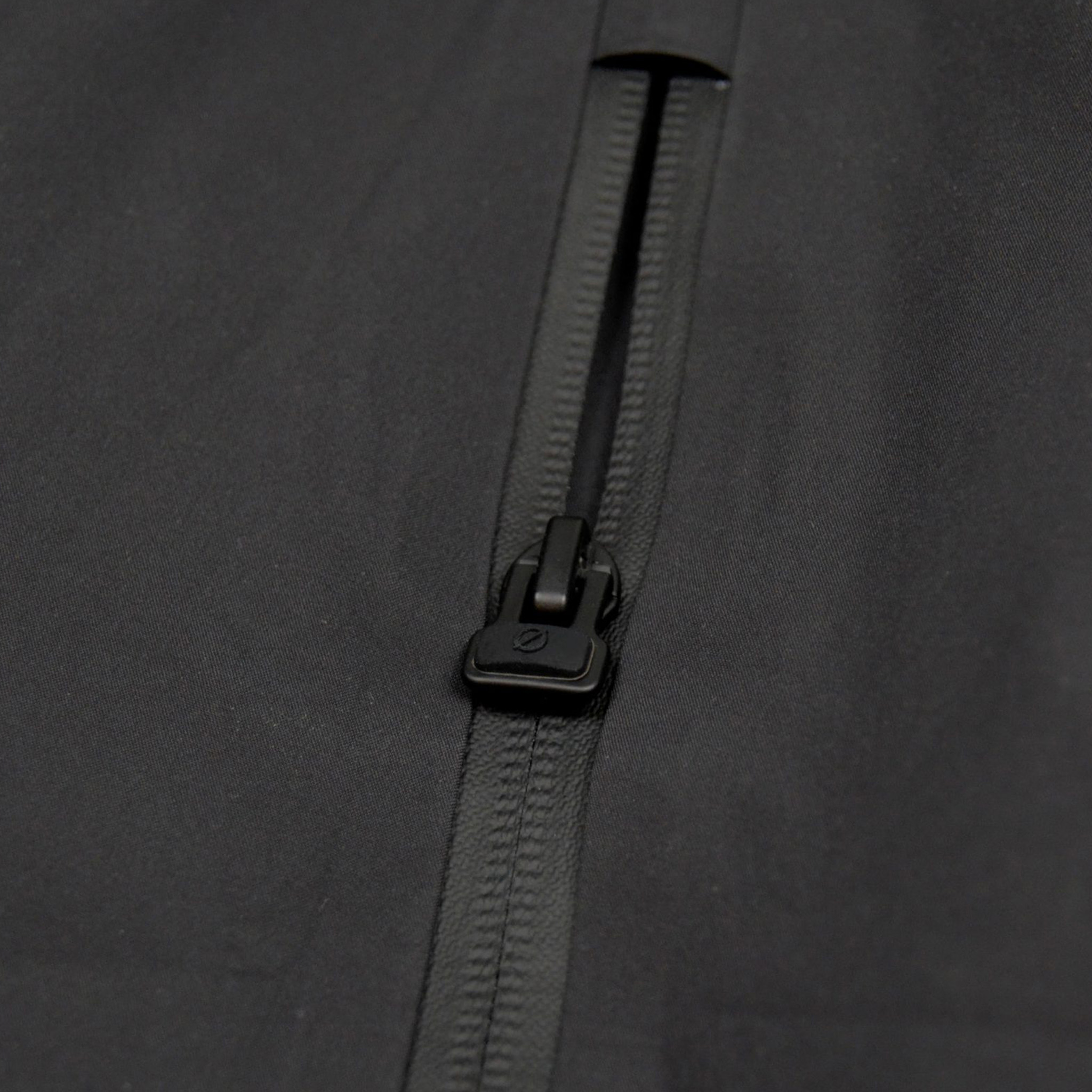 Detailaufnahme des hochwertigen Zipper-Accessoires mit ergonomischem Ø-Öffner an der schwarzen SNØVIT Nithya Nøva X Outdoor-Jacke.