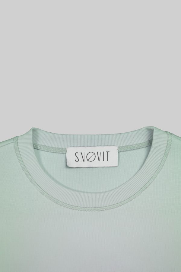 Nahaufnahme des SNØVIT Brand Tags im hellgrauen Arctic La Goone Sweatshirt.