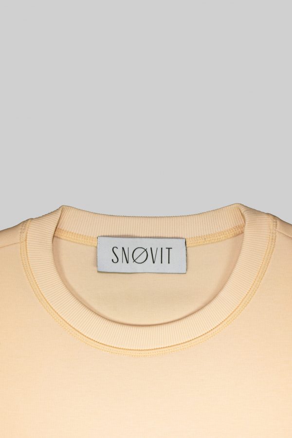 Nahaufnahme des SNØVIT Brand Tags im beigen Sweatshirt Phantom Nebula – sichtbar auf der Innenseite.