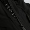 Nahaufnahme des gewebten SNØVIT Stripes an der schwarzen Nithya Nøva X Outdoor-Jacke, hochwertige Nylonstruktur sichtbar.