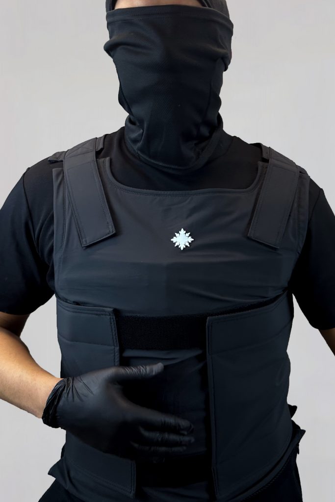 Vorderansicht eines Models mit der schwarzen DEFENX PRO Vanta Schutzweste – Fokus auf Sitz und Frontdesign.
