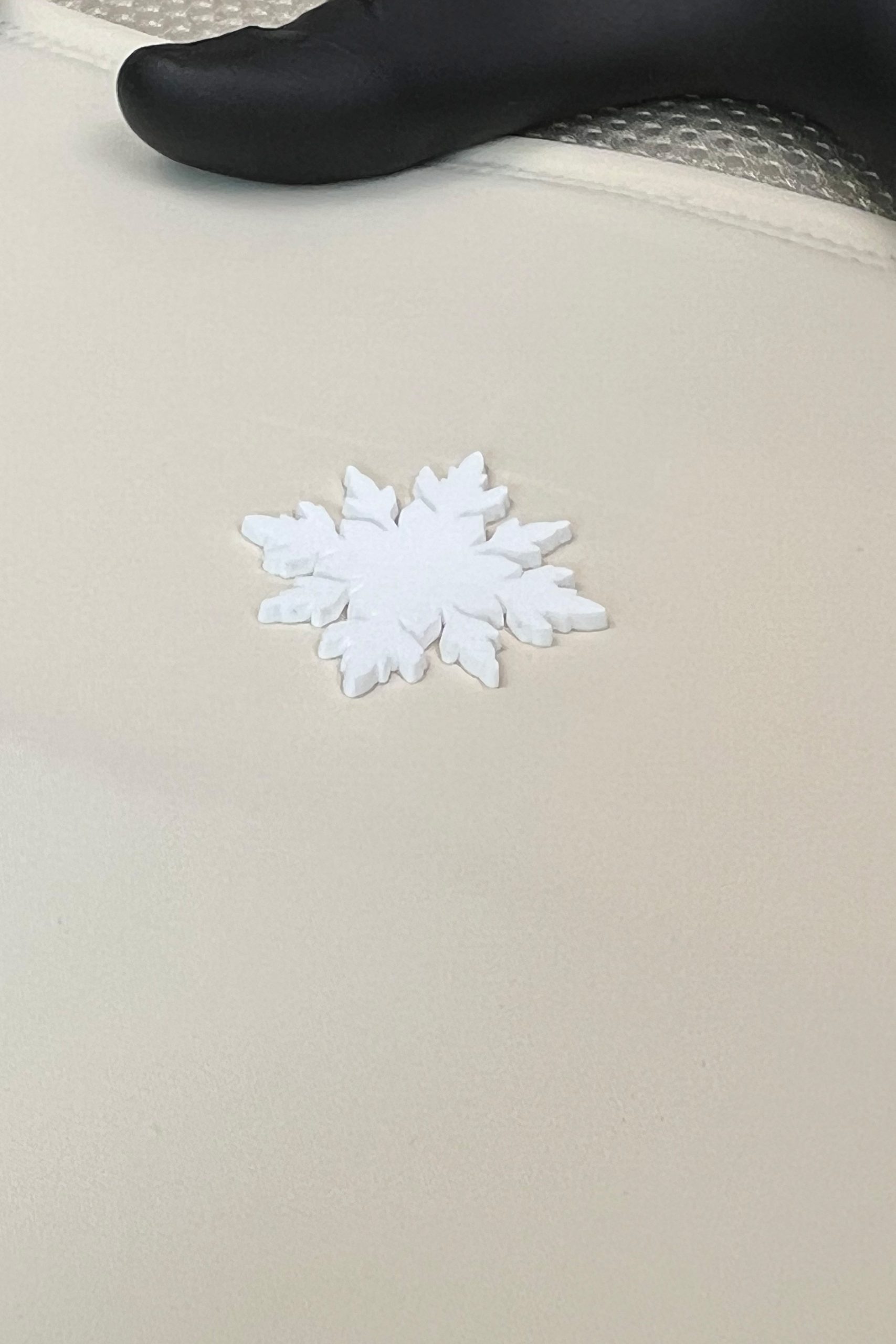 SNØVIT Schneeflocken-Logo als Detailaufnahme – dezentes Branding auf der Schutzweste