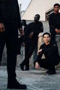 Modelguppe trägt das schwarze Snøvit Sweatshirt midnight core. Urbaner Hintegrrund auf dem Dach eines Hochhausgebäudes.